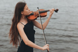 a girl plays the violin in nature